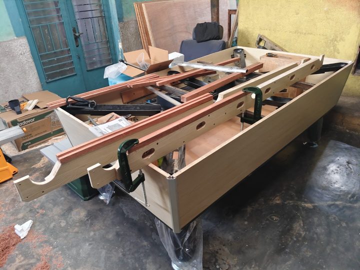 Structure, rails et éléments de la table en cours d’assemblage.